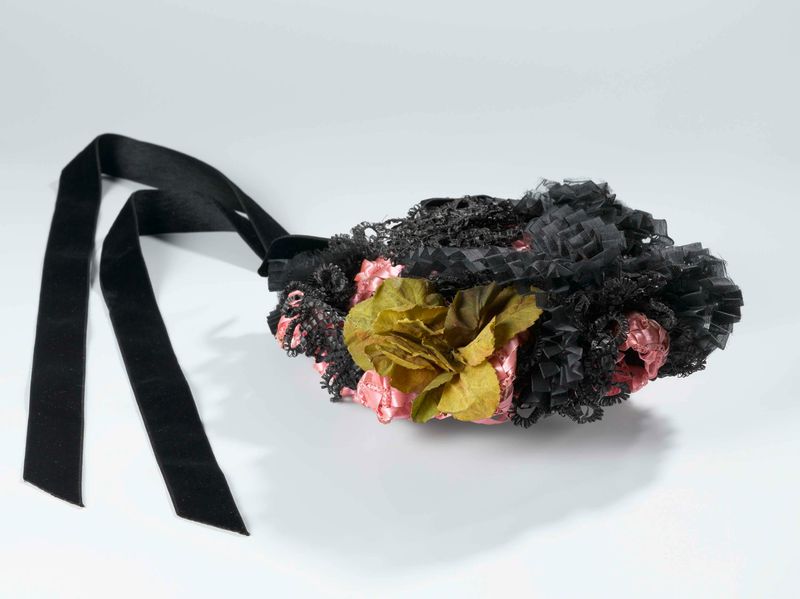 Arte decorativo con un sombrero rosa y cintas negras, obra de P. Mars & Co.