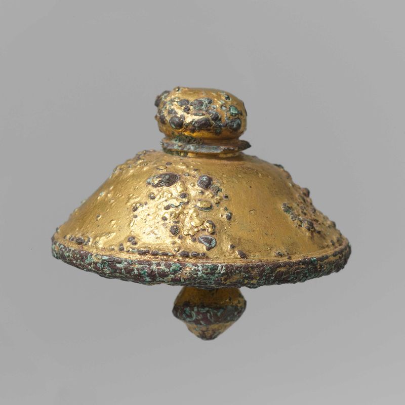 Campana de bronce de artista desconocido, mostrando intrincada pátina y textura.