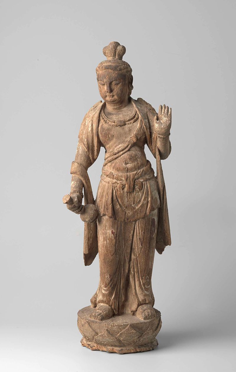 Escultura de madera de Guanyin por artista desconocido, de pie sobre una base de loto sosteniendo un jarrón.
