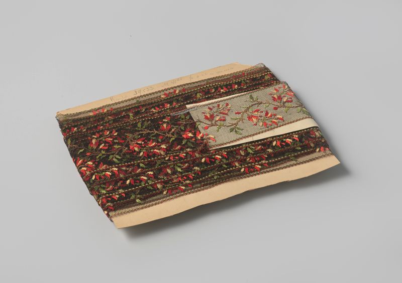 Composição decorativa de renda de Gustav Schnitzler, com tule preto e aplique colorido.